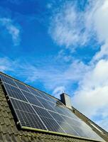 Solar panels producing clean energy on a roof of a residential house photo