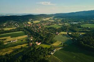 Aerial view of countryside area with village and mountains photo