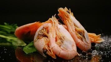 boiled shrimp with spices on black background video