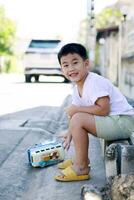 asiático niño jugando juguete en pueblo calle foto