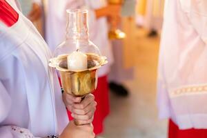 mujer vistiendo un blanco católico clerical túnica sostiene un vela a pagar saludos a dios.orando a pedir para un bendición desde dios. Navidad foto