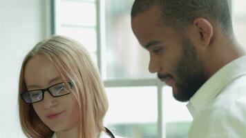 fermer de une patient avec une médecin qui regarder le résultats de une analyse sur le tablette video