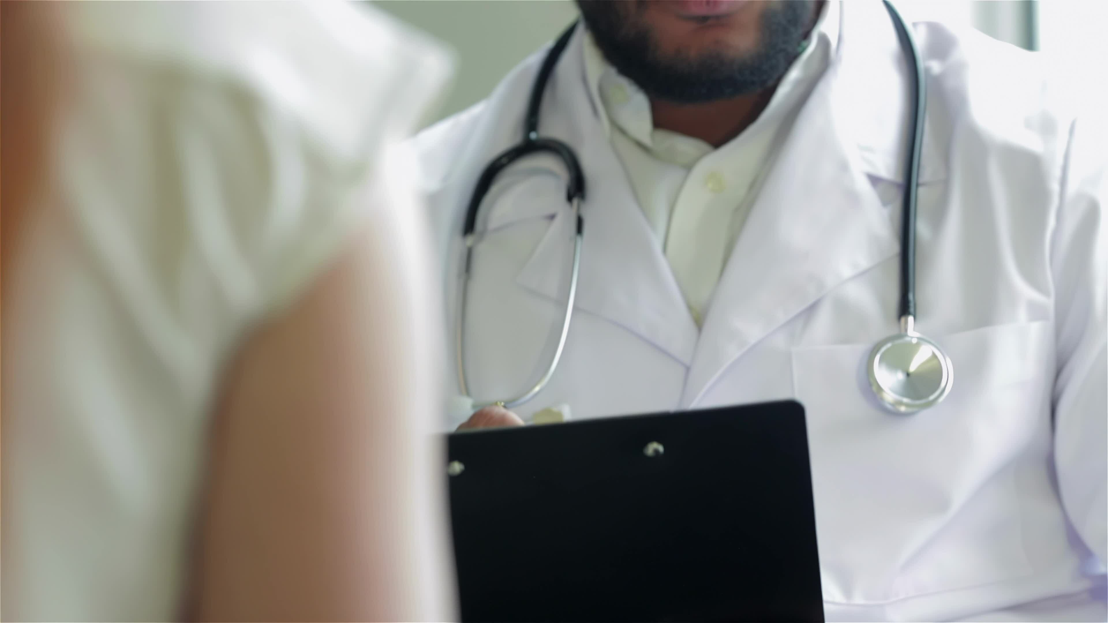 el médico asiente con la cabeza en la recepción del paciente y escribe
