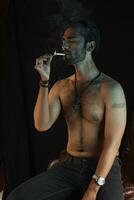 a man sitting on a leather chair with a cigarette photo