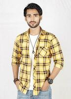 a man in a yellow and black checkered shirt photo