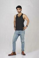 a man in jeans and a black tank top photo