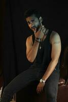 a man sitting on a leather chair with a cigarette photo