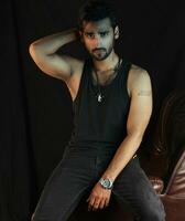 a man sitting on a leather chair with a cigarette photo