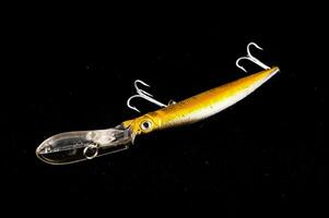 a yellow and black fishing lure on a black background photo