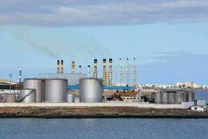 a factory with many tanks and pipes on the water photo