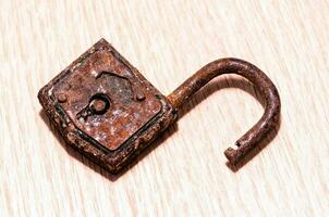 an old rusty lock on a wooden table photo