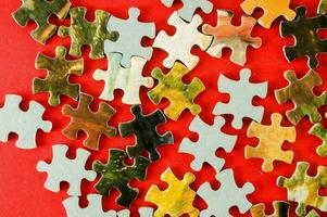 a pile of puzzle pieces on a red background photo