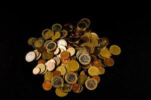 a pile of coins on a black background photo