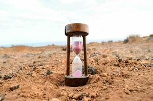 an hourglass sitting in the middle of a desert photo