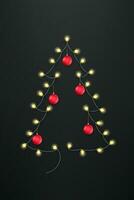 Abstract Christmas tree with and lighting garland and red baubles on black background vector