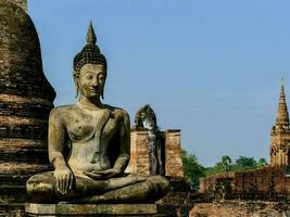 buddha statue in front of a temple in thailand photo
