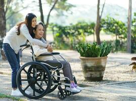 Asian senior woman in wheelchair with happy daughter. Family rel photo