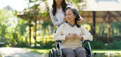 Asian senior woman in wheelchair with happy daughter. Family rel photo