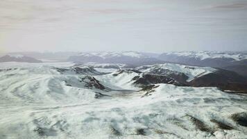 large snow patch left over on the volcanic rock field of a mountain in summer video