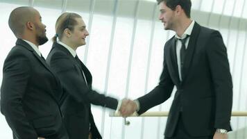 Two successful smiling businessmen shaking hands with each other video