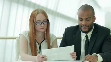 Two diligent businessmen meticulously discussing confidential documents video