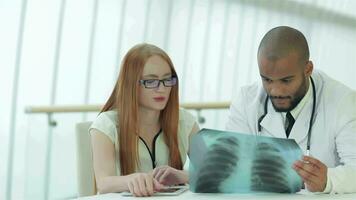 Doctor talking to patient while sitting at a table in the hospital video