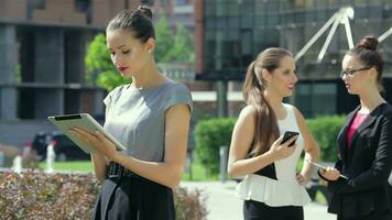 Business woman working on a tablet on the background of their business partners video