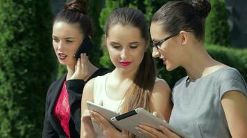 Business woman, working on the tablet, one of the girls looking at the camera video