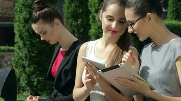 Successful business girls are browsing business terms on the tablet video