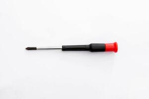 Small red and black screwdriver isolated white background. photo