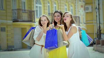 Tres linda muchachas emocionalmente saludar su amigos mientras compras video