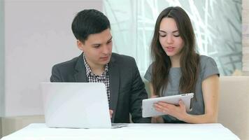 Young attractive business man and woman discussing collating data video