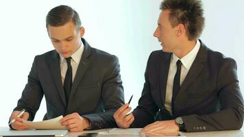 Businessmen discussing business plan on paper video