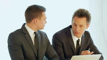 Businessmen sitting at a table discussing business plan video