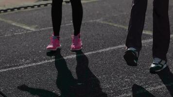 joven muchachas gastar formación ejercicios antes de el carrera. pierna músculo calentar arriba ejercicios video