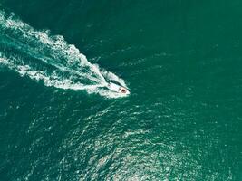 Aerial view of Speed boat at high speed in the aqua sea, Drone view photo