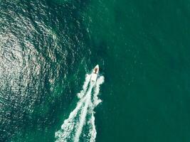 Aerial view of Speed boat at high speed in the aqua sea, Drone view photo