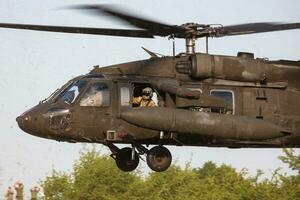 US Army Sikorsky UH-60 Black Hawk military helicopter at air base. Aviation and rotorcraft. Transport and airlift. Fly and flying. photo