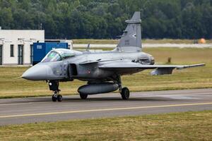 Saab JAS 39 Gripen military fighter jet plane at air base. Air force flight operation. Aviation and aircraft. Air defense. Military industry. Fly and flying. photo