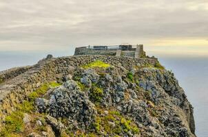 the castle on the top of a cliff overlooking the ocean photo