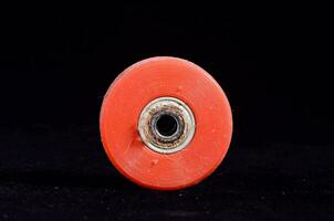 a red plastic wheel with a hole in it photo