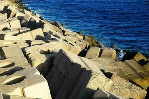 a wall of concrete blocks on the side of the ocean photo