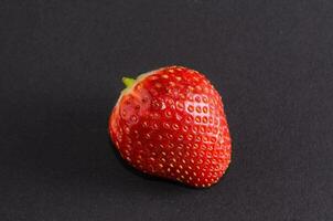 a single strawberry on a black background photo