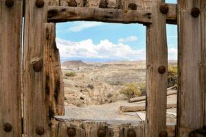 a view through a wooden fence into the desert photo