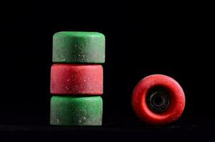 un apilar de verde y rojo patinetas en un negro antecedentes foto