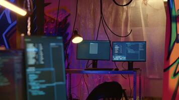 Programas interface em computador tela mostrando programação código usava para fazer malware dentro esvaziar armazém com grafite pulverizado em paredes. hacking roteiro corrida em pc monitores dentro subterrâneo base video
