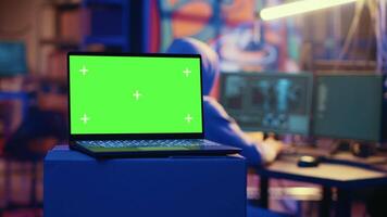 Green screen laptop used by hackers in underground hideout to write lines of code, developing virus that get past security systems. Chroma key device used by evil developers in hidden bunker video