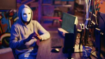 hacker vistiendo anónimo máscara amenaza víctima con despliegue malware diseñado a explotar red puertas traseras Si su demandas son no reunió, rodaje rescate vídeo después eludiendo seguridad medidas video