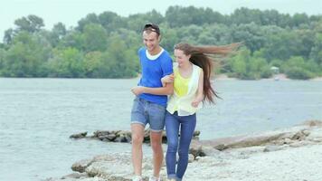 meisje vent gesprongen Aan zijn terug en ze rennen Aan de strand langzaam beweging video