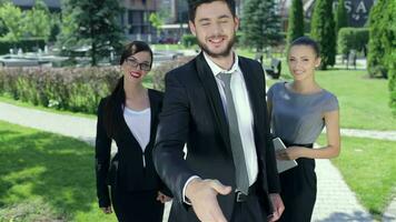 Successful businessman shaking hands standing in the company of two women video